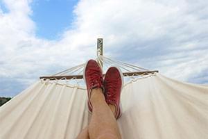 person in hammock with blue sky backdrop