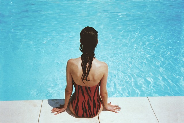 woman sitting beside pool