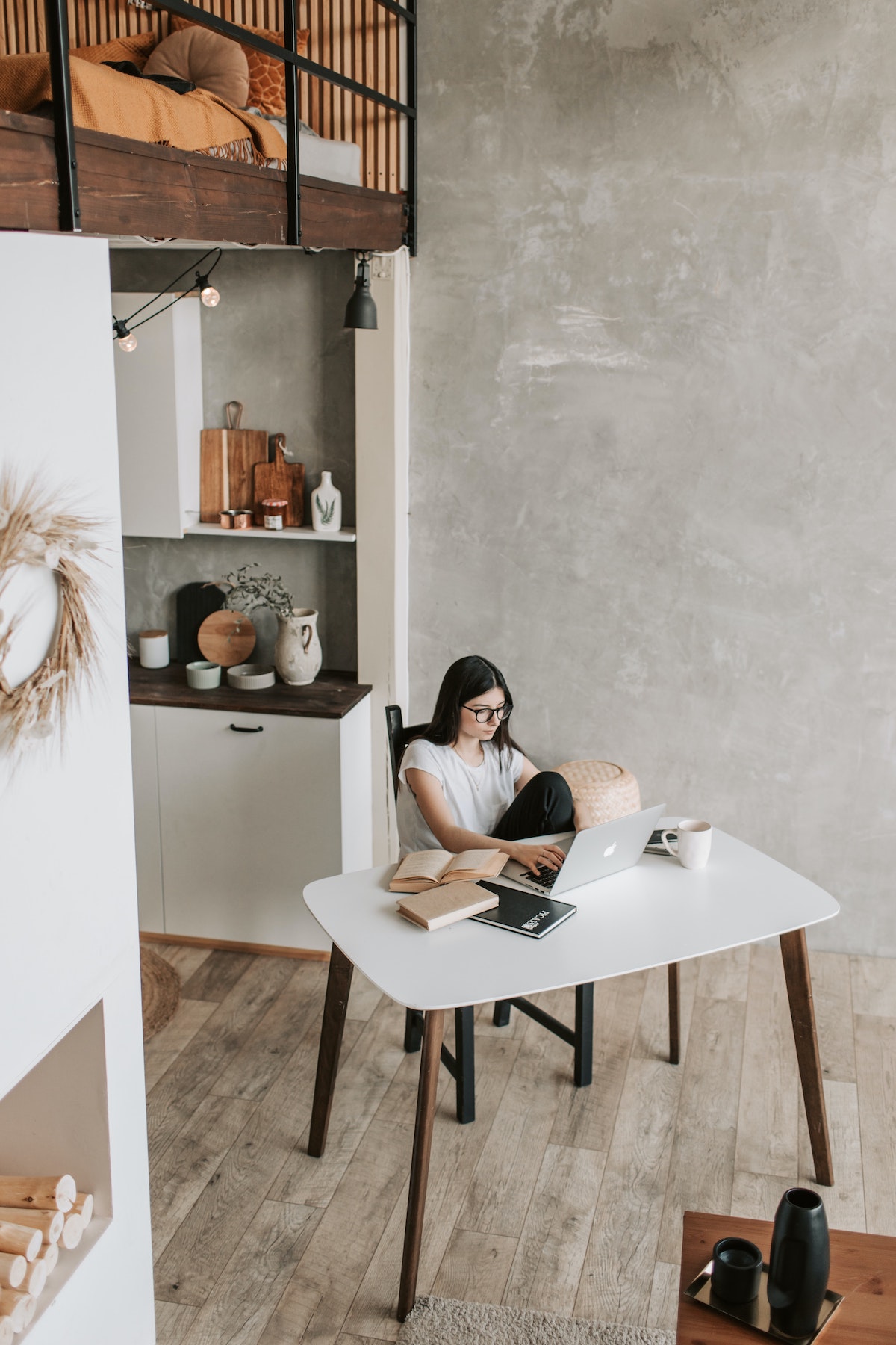 A woman sitting at a computer at the kitchen table