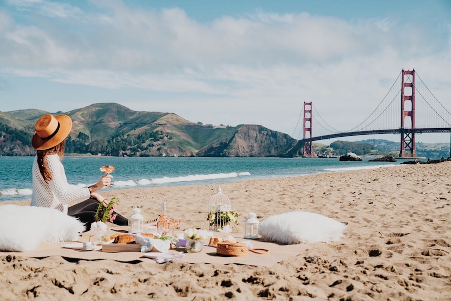 Woman having a beach picnic by the Golden Gate Bridge