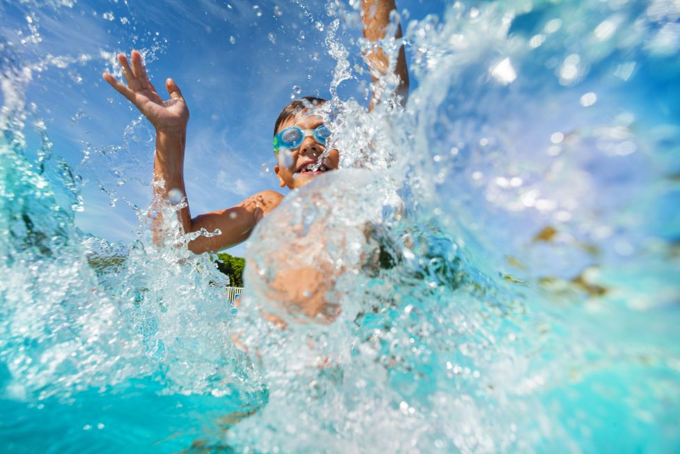 boy splashing in pool