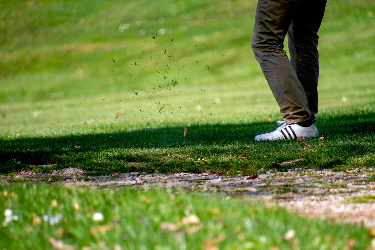 Close up shot of golf course grass flying into the air after tee time.