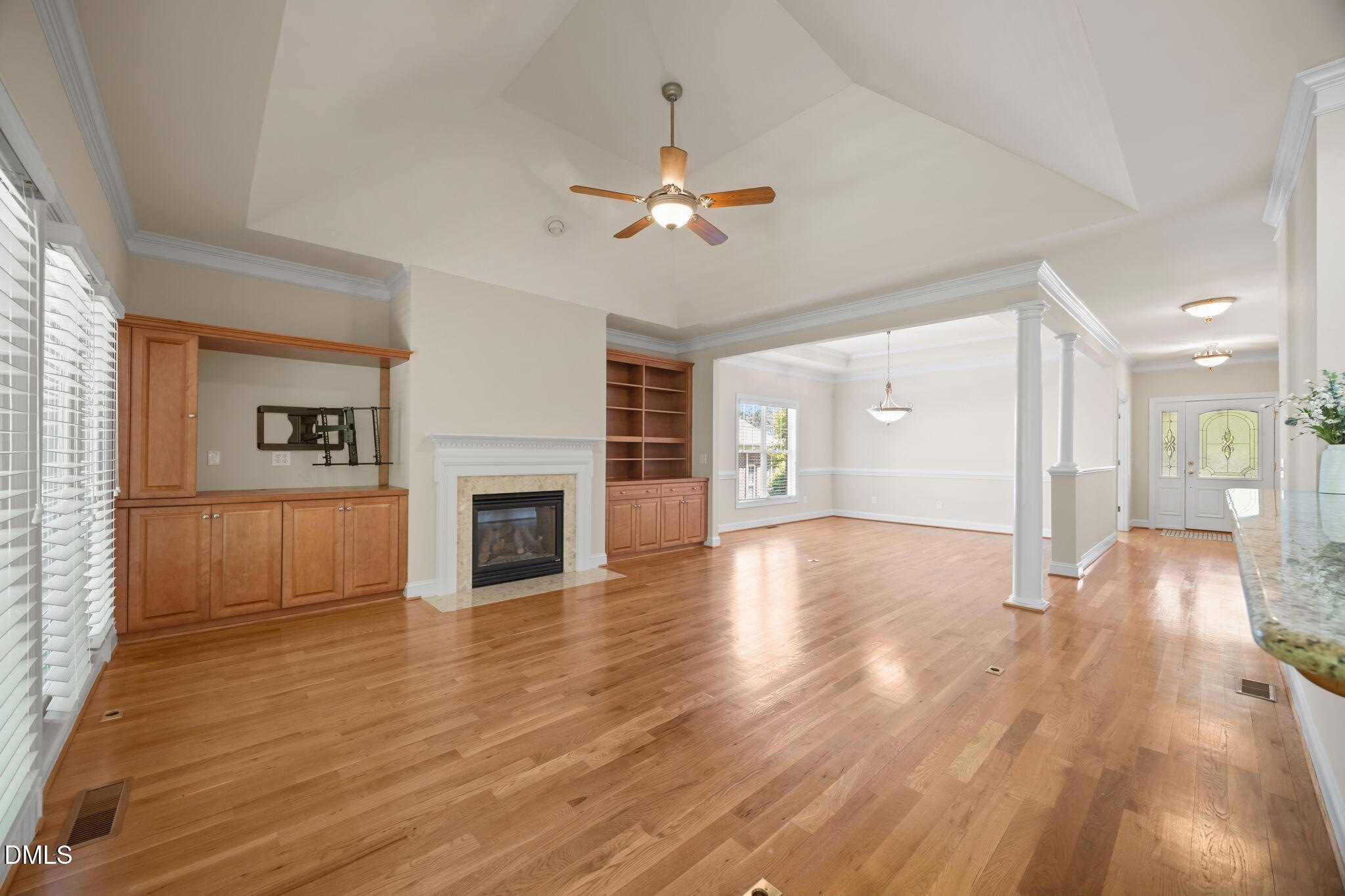 Daltons Ridge open living room with hardwood floors, a fireplace, and built ins 