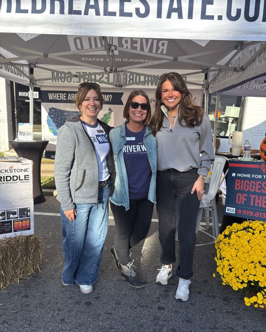 Three women smiling together at the RiverWILD Harvest Festival booth