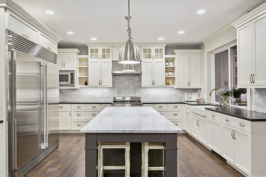 Luxurious kitchen interior with granite countertops, a chrome fridge, and stove.