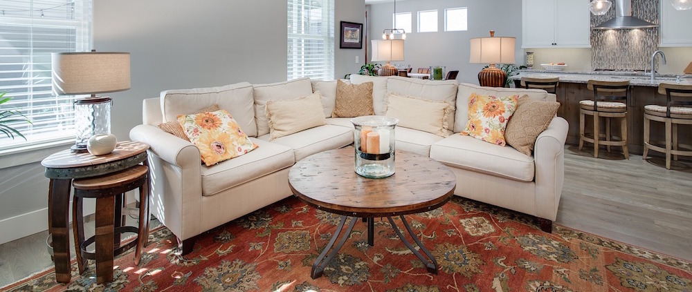 A living room with a large beige couch in the center.