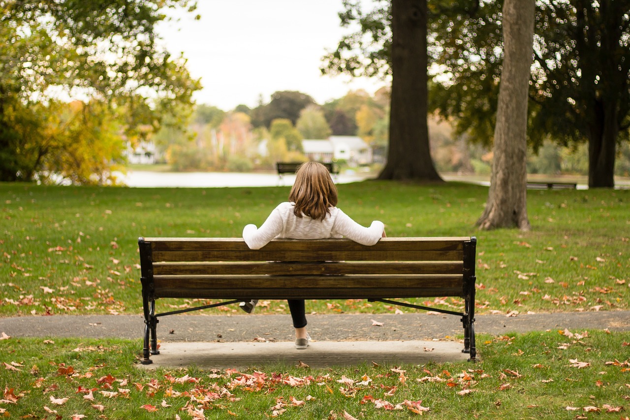 Woman sitting relaxed on a park bench.