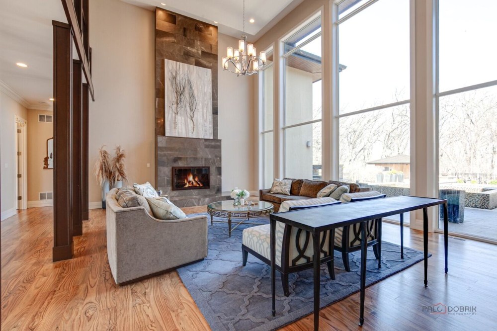 Staged living room with fireplace and floor-to-ceiling windows