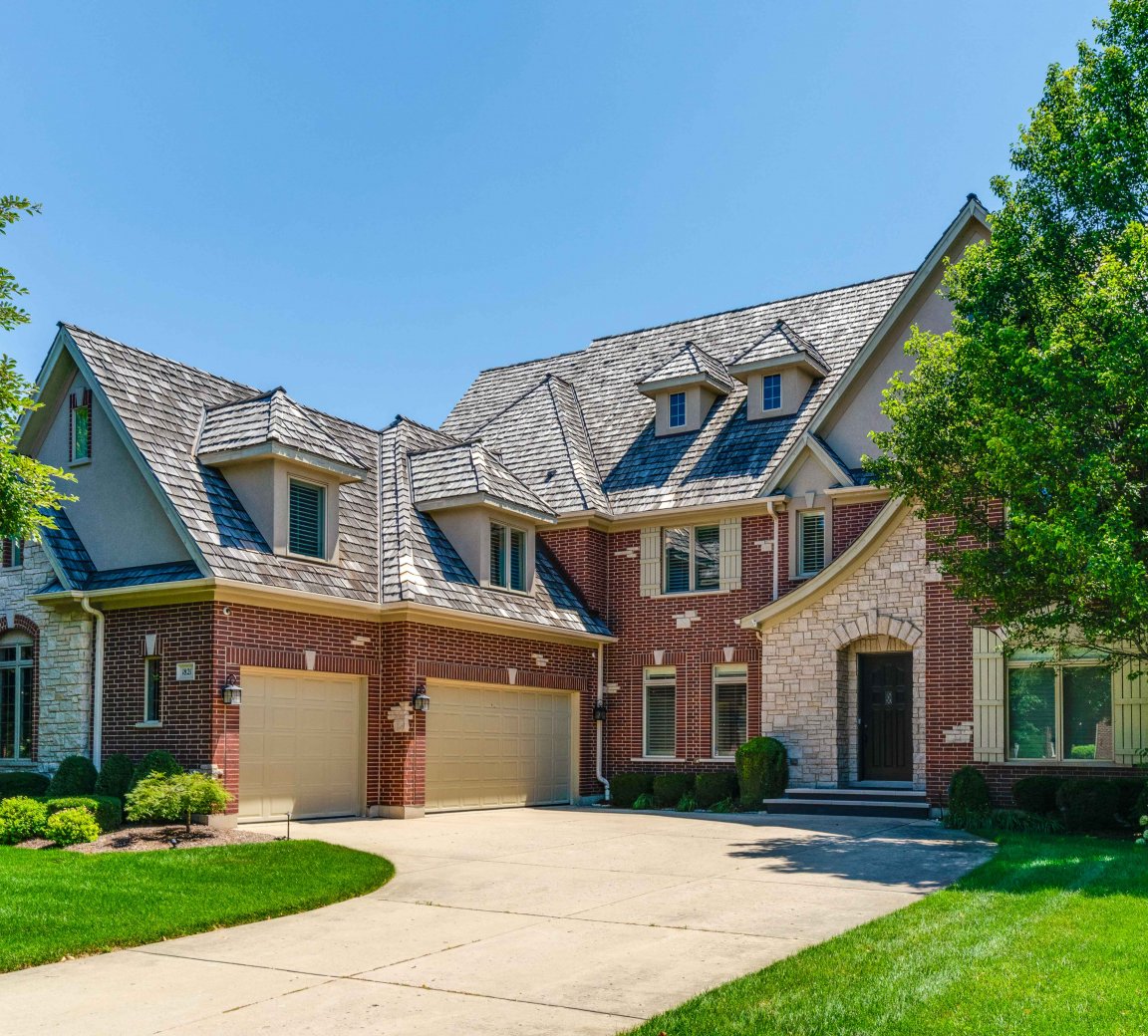 Craftsman home with arched front porch and lush landscaping