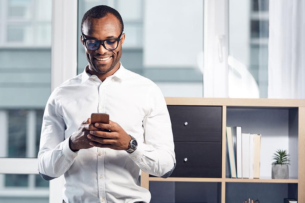 Smiling man typing on a phone