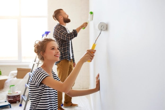A woman and man painting a wall