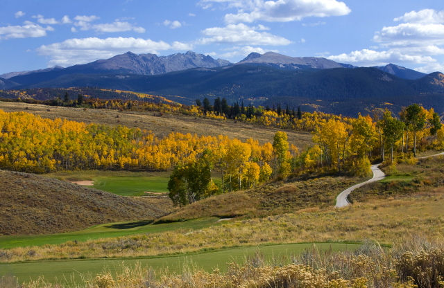 A golf course on rolling hills overlooking a mountain range in Edwards, CO.